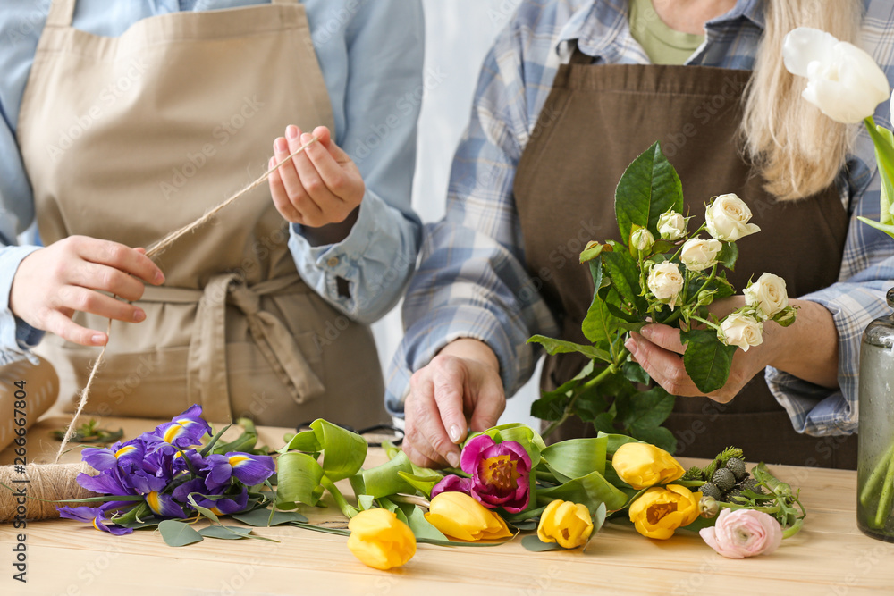 Two people making flower bouquets